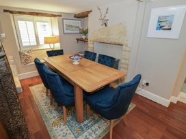 A dining room with a wooden table and blue chairs at 23 New Church Street Tetbury