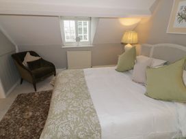 A bedroom with a bed and chair at 23 New Church Street in Tetbury