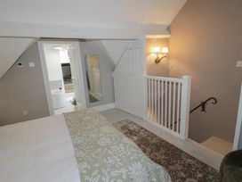 A bedroom with a staircase and a mirror view at 23 New Church Street Tetbury