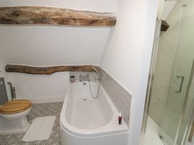 A bathroom featuring a bathtub, toilet, and shower at 23 New Church Street Tetbury