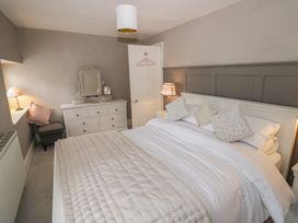 A bedroom with a bed and dresser at 23 New Church Street, Tetbury