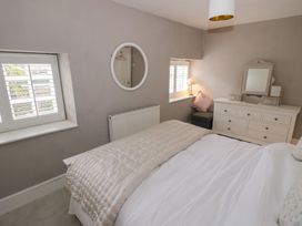 A bedroom with a bed and dressing table at 23 New Church Street in Tetbury