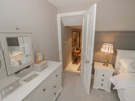 A bedroom with a bed, dresser, and mirror at 23 New Church Street Tetbury