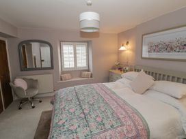 A bedroom with a bed and a chair at 23 New Church Street Tetbury