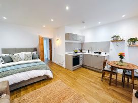 A studio apartment with a kitchen and bed at Ammil Bespoke