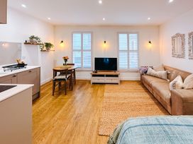 A living room with a sofa and television at Ammil Bespoke