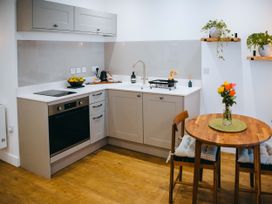A kitchen with cabinets and a dining table at Ammil Bespoke