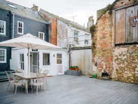 An outdoor area with table and chairs under an umbrella at Ammil Bespoke