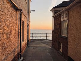 A walkway between buildings leading to the sea at Ammil Bespoke