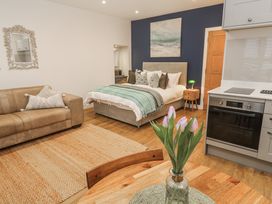 A living room with a bed, sofa, and kitchen appliances at Ammil Bespoke St Ives