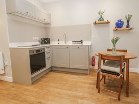 A kitchen with a dining table and flowers at Ammil Bespoke St Ives