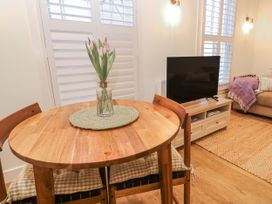 A living room with a table and flowers at Ammil Bespoke in St Ives