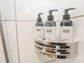A shower dispenser holding shampoo, conditioner, and body wash at Ammil Bespoke in St Ives
