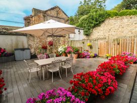An outdoor area with a table, chairs, and flower pots at Ammil Bespoke in St Ives