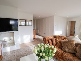 A living room with a couch and television at Three Ways in South Lopham near Garboldisham