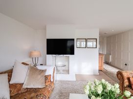 A living room with a television and a sofa at Three Ways South Lopham near Garboldisham
