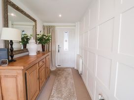 A hallway with a mirror and wooden cabinet at Three Ways in South Lopham near Garboldisham
