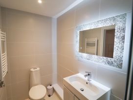 A bathroom with a toilet, sink, and mirror at Three Ways in South Lopham near Garboldisham