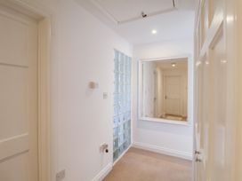A hallway with a mirror and glass block wall at Three Ways in South Lopham near Garboldisham