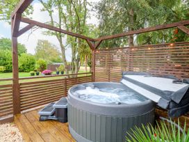 A hot tub on wooden decking in a garden at Three Ways South Lopham near Garboldisham