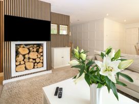 A living room with a fireplace and television at Three Ways South Lopham near Garboldisham