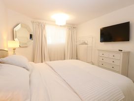 A bedroom with a bed, dresser, and television at Three Ways in South Lopham near Garboldisham