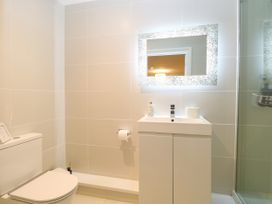 A bathroom with toilet, sink, shower and mirror at Three Ways in South Lopham near Garboldisham
