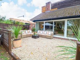 A garden area with a sofa and umbrella at Three Ways South Lopham near Garboldisham