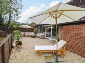 A garden area with furniture and umbrellas at Three Ways South Lopham near Garboldisham