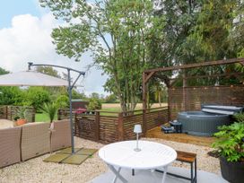 A garden area with a table and chairs and a hot tub at Three Ways in South Lopham near Garboldisham