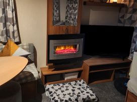 A living room with a fireplace and television at Elm 33 in Scarborough