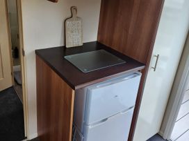 A kitchen counter with a fridge and cutting board at Elm 33 in Scarborough