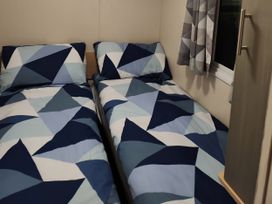 A bedroom with two beds and patterned bedding at Elm 33 Scarborough