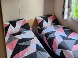 A bedroom with two beds and colorful bedding at Elm 33 in Scarborough