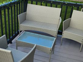 A seating area with a sofa and chairs on a deck at Elm 33 in Scarborough