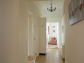 A hallway with a chandelier and door leading to another room at 4 Ringrone Salcombe
