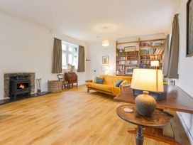 A living room with a sofa and bookshelf at School House in Ivybridge