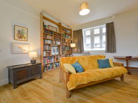 A living room with a bookshelf and sofa at School House in Ivybridge
