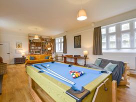 A living room with a pool table and bookshelf at School House in Ivybridge