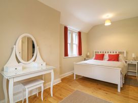 A bedroom with a bed and vanity desk at School House in Ivybridge