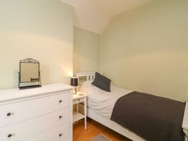 A bedroom with a bed, mirror, and chest of drawers at School House in Ivybridge