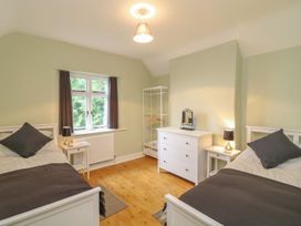 A bedroom with two beds and a dresser at School House in Ivybridge