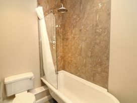 A bathroom with a bathtub and a toilet at School House in Ivybridge