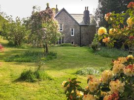 A garden with a house in the background at School House in Ivybridge