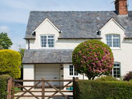 A house with a garage door and a landscaped garden at Glencoe Cottage in Broadway