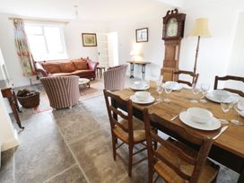 A dining room with a table and seating area at Glencoe Cottage in Broadway