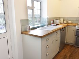 A kitchen with a sink and various kitchen appliances at Glencoe Cottage in Broadway