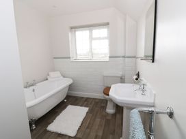 A bathroom with a bathtub and washbasin at Glencoe Cottage in Broadway