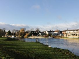 A river with houses and trees along the bank at Glencoe Cottage in Broadway