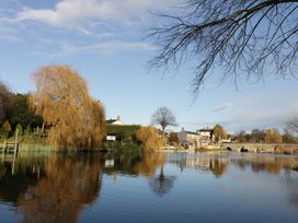 A river with a bridge and trees at Glencoe Cottage in Broadway